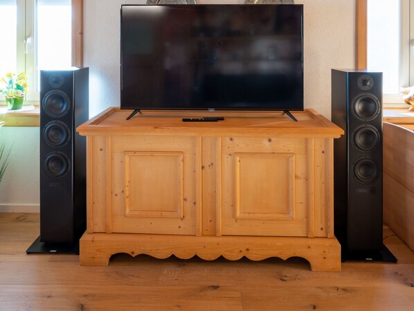 A wooden entertainment center with a flat-screen TV and two speakers. - Gesamtes Ferienhaus in Buchenberg mit Grill, Garten und Terrasse by Interhome (Buchenberg)