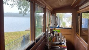 Eine schmale Küche mit Holzwänden und großen Fenstern mit Blick auf einen See.
