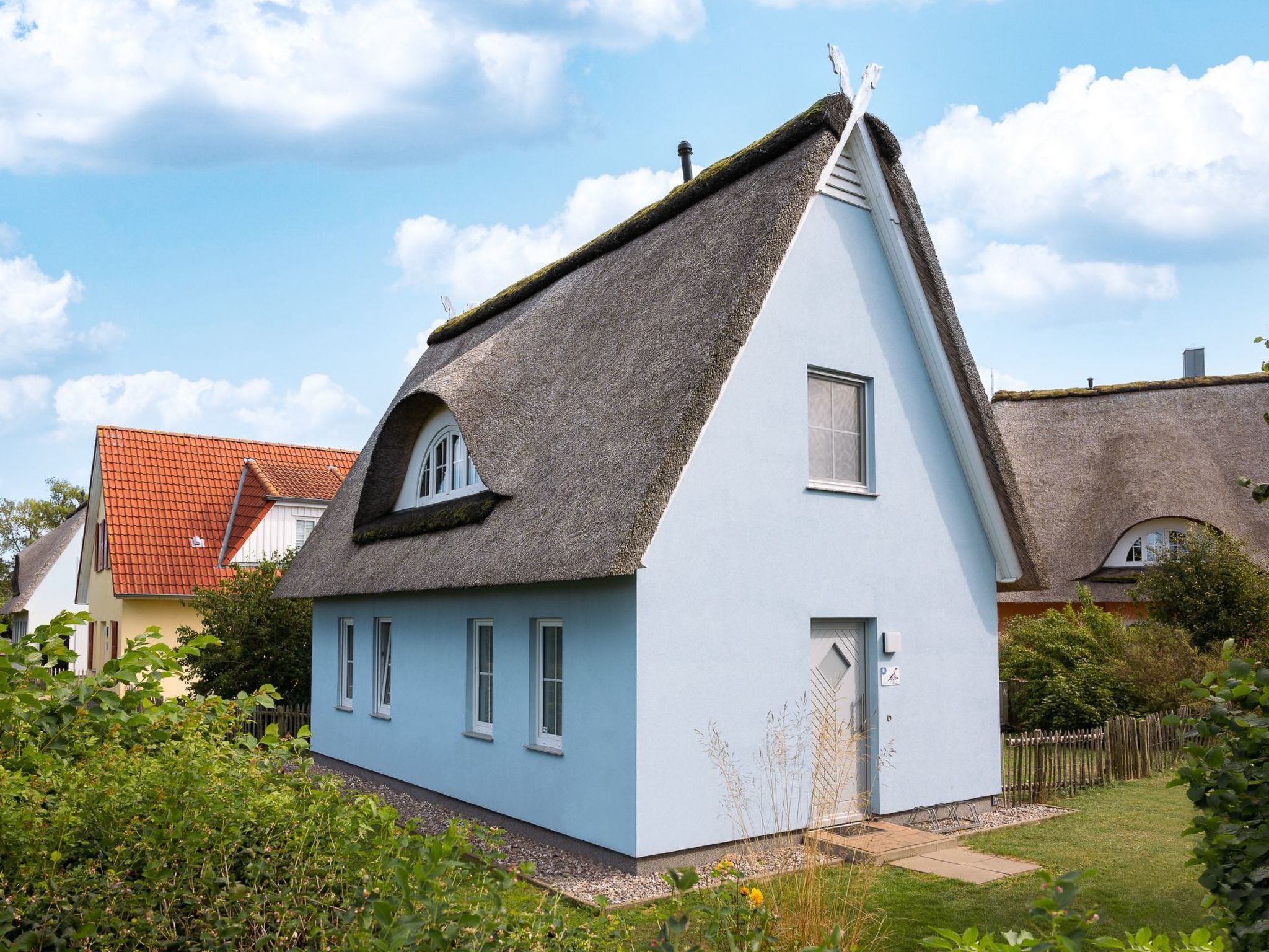 Une maison de plain-pied avec un toit de chaume et une petite fenêtre.