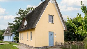 A small, single-story house with a thatched roof and a yellow facade. - Reethaus Seepferdchen by Interhome (Alt Jassewitz)