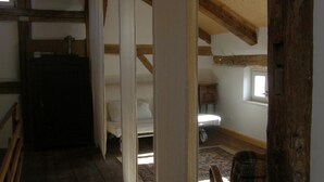 A bedroom with a wooden ceiling, a bed, a nightstand, and a window. - Ferienhaus by Interhome (Schernfeld)
