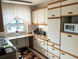 A compact kitchen with a window, a toaster, a coffee maker, and a microwave. - Freistehendes Ferienhaus mit Südbalkon by Interhome (Marktrodach)