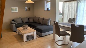 Una sala moderna con un sofá, una mesa de centro y un comedor con sillas y una mesa.