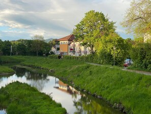 Uitzicht op een rivier met een gebouw voorzien van balkons en een tuin.