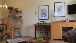 Zona pranzo con tavolo, sedie e televisore.