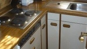 A kitchen with a stove, sink, and cabinets. - Haus am See mit Fasssauna, Liegewiese und Grill by Interhome (Waldkirchen)