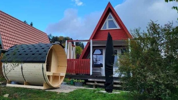 A house with a red roof and a triangular gable. - Haus am See mit Fasssauna, Liegewiese und Grill by Interhome (Waldkirchen)