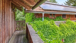 Una baita di legno con un portico coperto e un giardino.