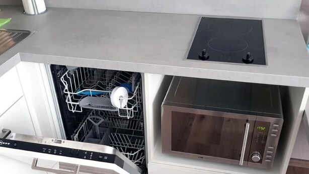 A compact kitchen with a dishwasher, a microwave, and a stovetop. - Wohnung in Neckarwestheim by Interhome (Neckarwestheim)