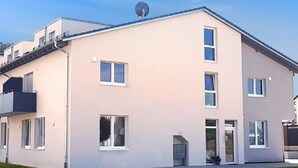 A modern two-story building with a flat roof, multiple windows, and a satellite dish. - Wohnung in Neckarwestheim by Interhome (Neckarwestheim)