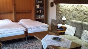 A room with two beds, a sofa, a small table with a lamp, and a bookshelf. - in Bernsfeld mit großem Garten by Interhome (Atzenhain)