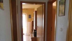 Un corridoio con pavimento in legno e porte che conducono ad altre stanze.