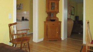 Een kamer met houten vloer, een houten kast en een stoel.