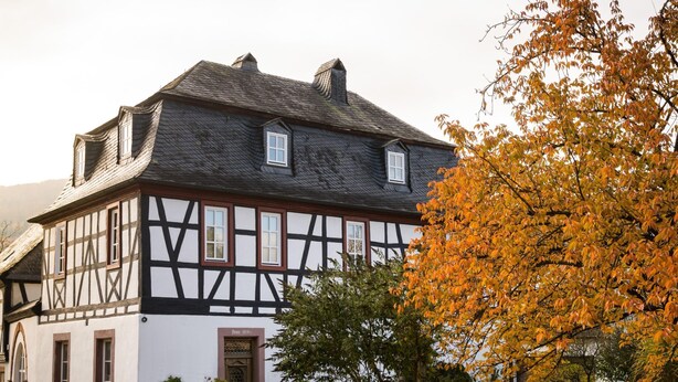 A traditional half-timbered house with a steep gabled roof, a small front porch with potted plants, and a white picket fence. - in Traben mit Kleinem Garten by Interhome (Traben-Trarbach)