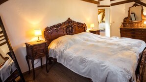 A bedroom with a large bed, wooden headboard, two bedside tables with lamps, and a mirror on the wall. - in Traben mit Kleinem Garten by Interhome (Traben-Trarbach)