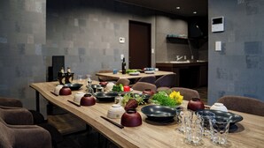 A dining area with a long table set for a meal, featuring various dishes and utensils. - PROSTIMO (Bibai)