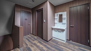 A modern hallway with wooden walls and a white sink area. - PROSTIMO (Bibai)