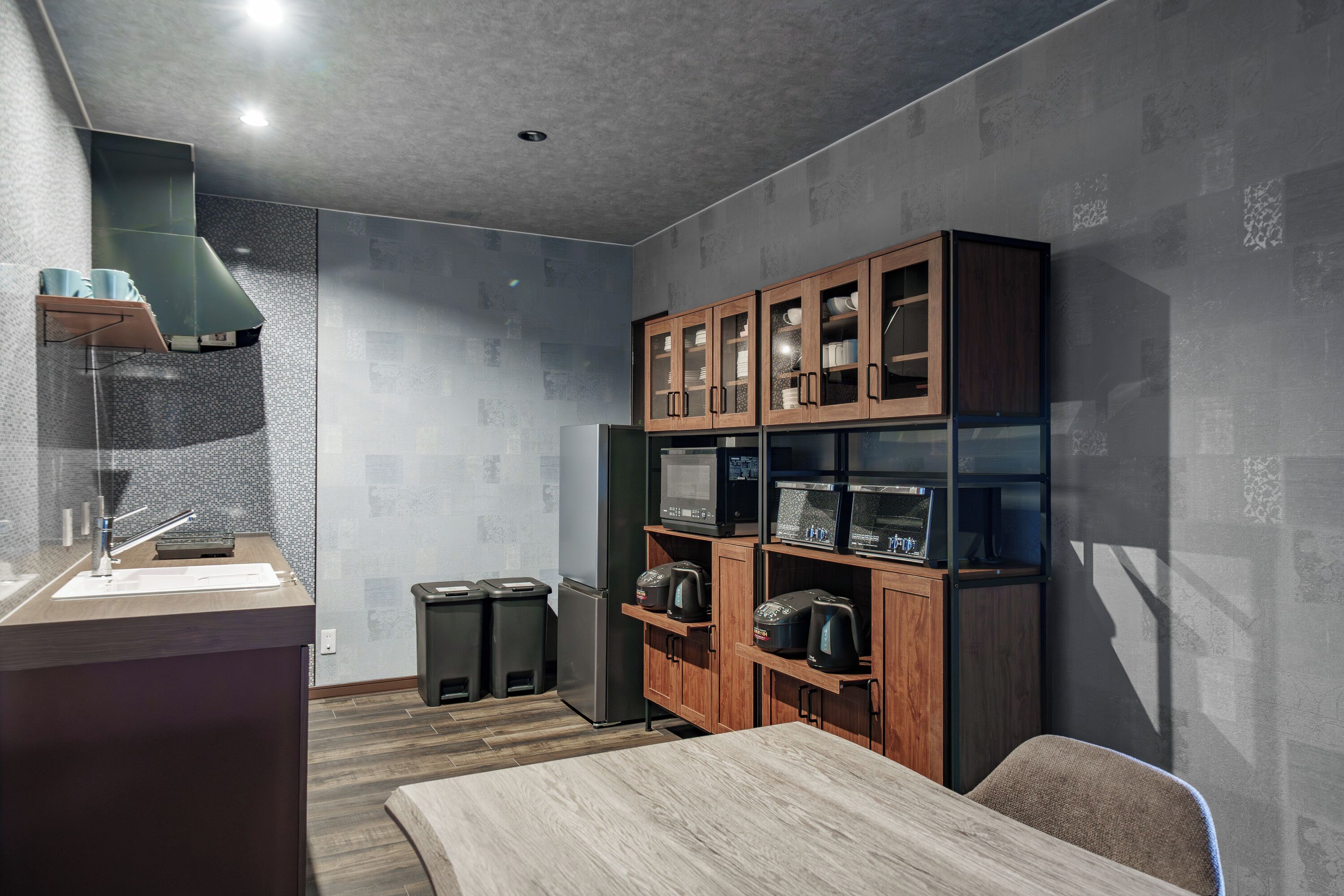 A modern kitchen with a wooden cabinet, stainless steel appliances, and a wooden dining table.