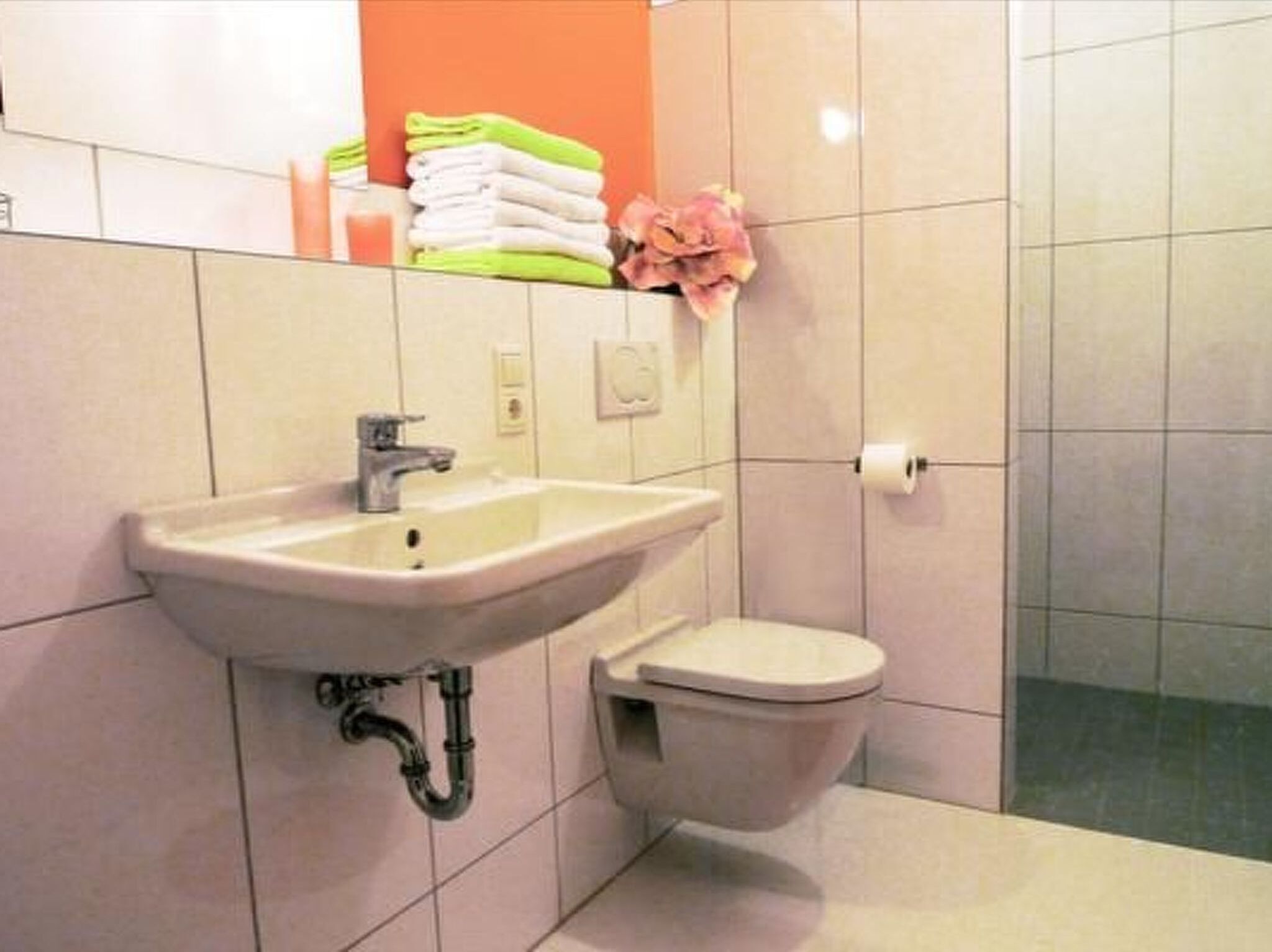 A bathroom with a sink, toilet, and a towel rack with folded towels.