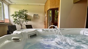 A hot tub with water jets, a small step stool, and a 'RELAX' sign on the wall. - Ober Langengarten by Interhome (Pittenbach)