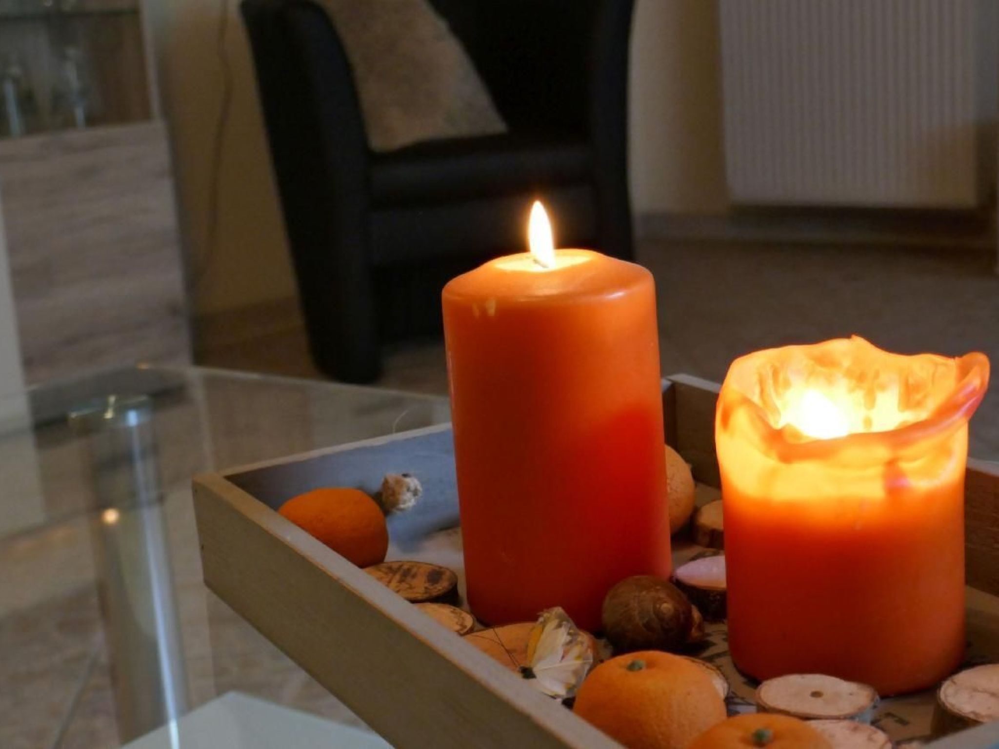 Ein Kerzenlicht-Tisch mit zwei Kerzen und einer Schale mit Nüssen und Trockenfrüchten.