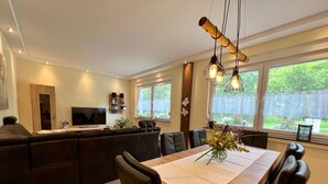A modern kitchen with a dining area, large windows, and a TV. - Suite am Radweg by Interhome (Pittenbach)