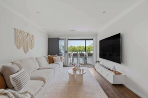 A modern living room with a sofa, coffee table, and TV.