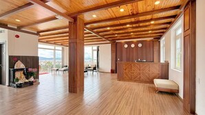 A spacious room with wooden flooring and a high ceiling with exposed beams. - KIEN DALAT (Lam Vien - Da Lat)