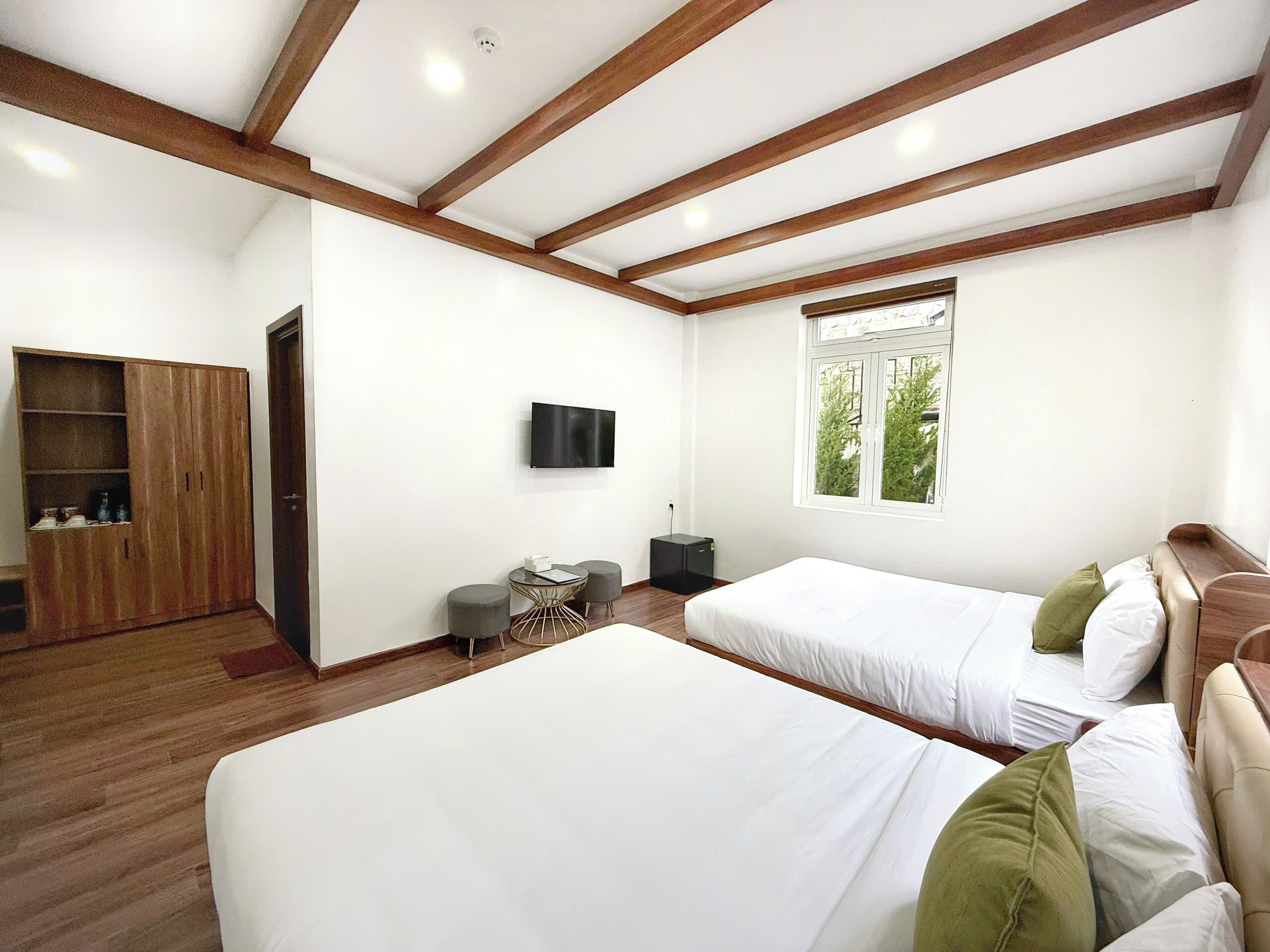 Une chambre moderne avec deux lits, une télévision et une armoire.