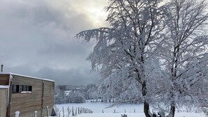 A snow-covered landscape with a wooden building and a tree. - Exklusives Ferienhaus mit Terrasse und Garten by Interhome (Simmerath)