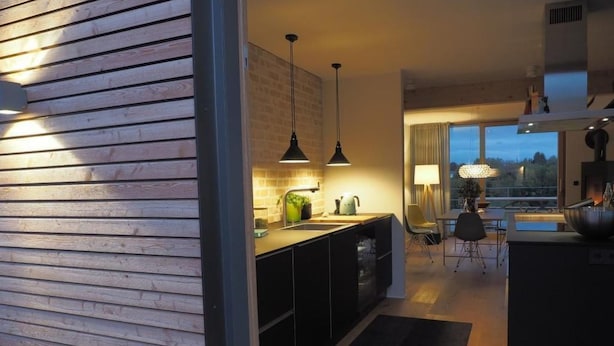 A modern kitchen with black cabinets, a wooden countertop, and pendant lighting. - Exklusives Ferienhaus mit Terrasse und Garten by Interhome (Simmerath)