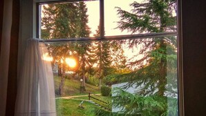 A window with a view of a grassy area, trees, and a building in the background. - Belle Vue by Interhome (Husen)