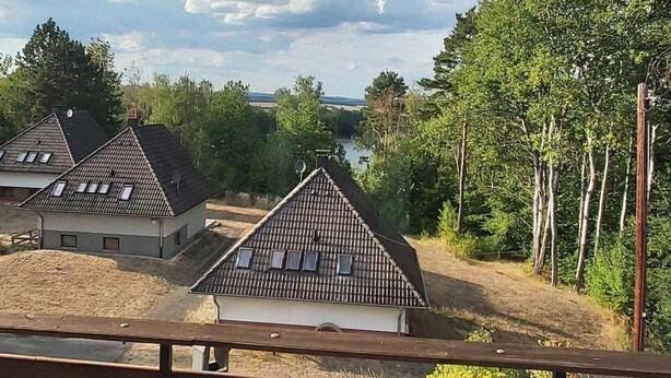 A view of a residential area with houses and a lake in the background. - Charmantes Ferienhaus mit Blick auf den Silberse by Interhome (Frielendorf)