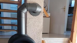 A wood-burning stove in a room with a wooden bench and a textured wall. - Charmantes Ferienhaus mit Blick auf den Silberse by Interhome (Frielendorf)