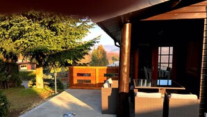 Un espace extérieur aménagé avec des meubles en osier, une clôture en bois et un chemin en pierre.