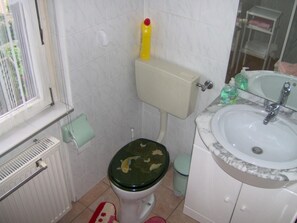 Ein Badezimmer mit Toilette, Waschbecken und Fenster.