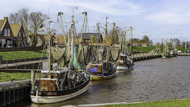 A canal with several fishing boats docked along the shore. - Apartment Marion by Interhome (Greetsiel)