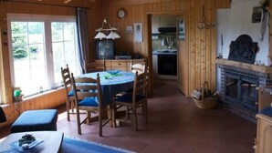 Ein gemütliches Blockhaus-Interieur mit Essbereich, Küche und Kamin.