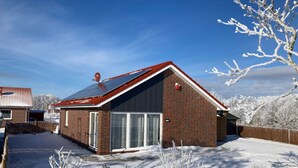 A single-story brick house with a red roof, a satellite dish, and a garage. - in Sehestedt mit Garten by Interhome (Jade)