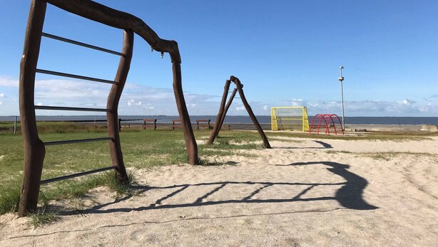 A sandy beach with wooden structures and a yellow goal post. - in Sehestedt mit Garten by Interhome (Jade)