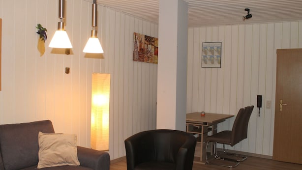 Ein gemütliches Wohnzimmer mit einer Couch, einem Couchtisch und einem Essbereich mit Tisch und Stühlen.