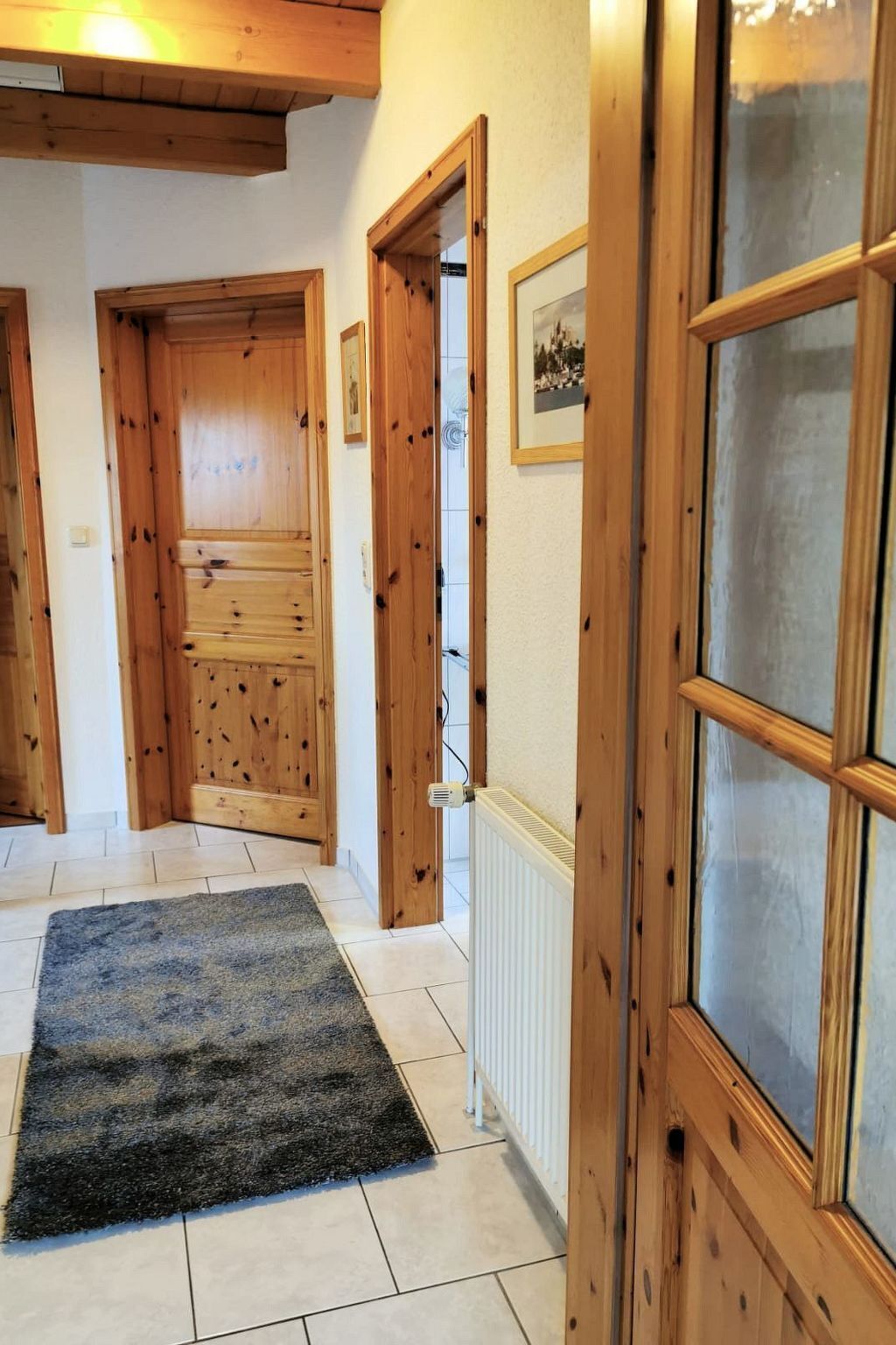 A hallway with wooden doors and a radiator.