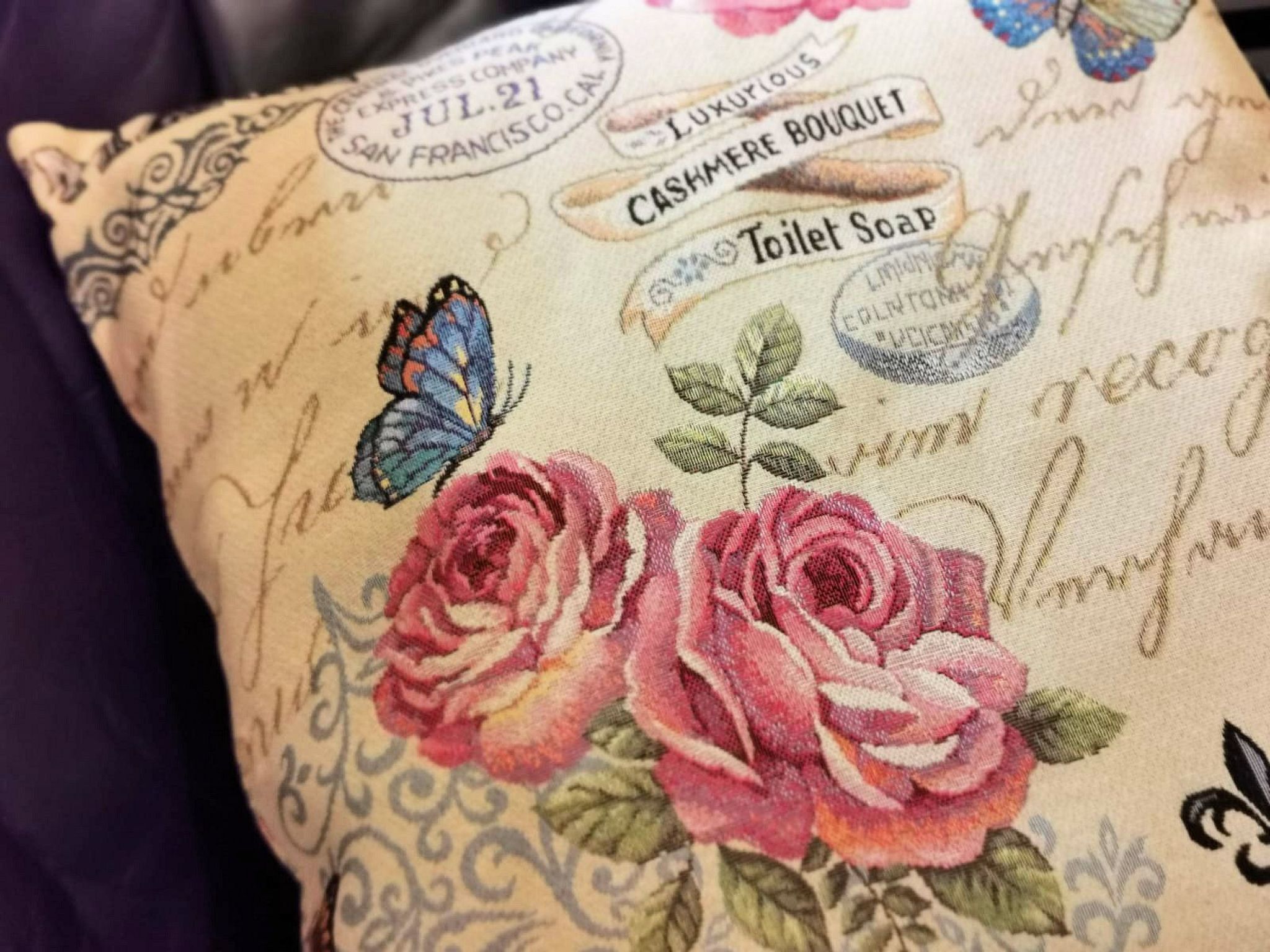 A pillow with embroidered text and floral designs.