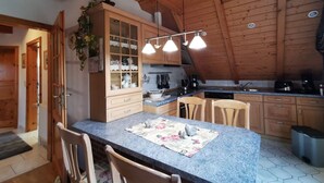 Una cocina con armarios de madera, encimera de granito y una zona de comedor con sillas.