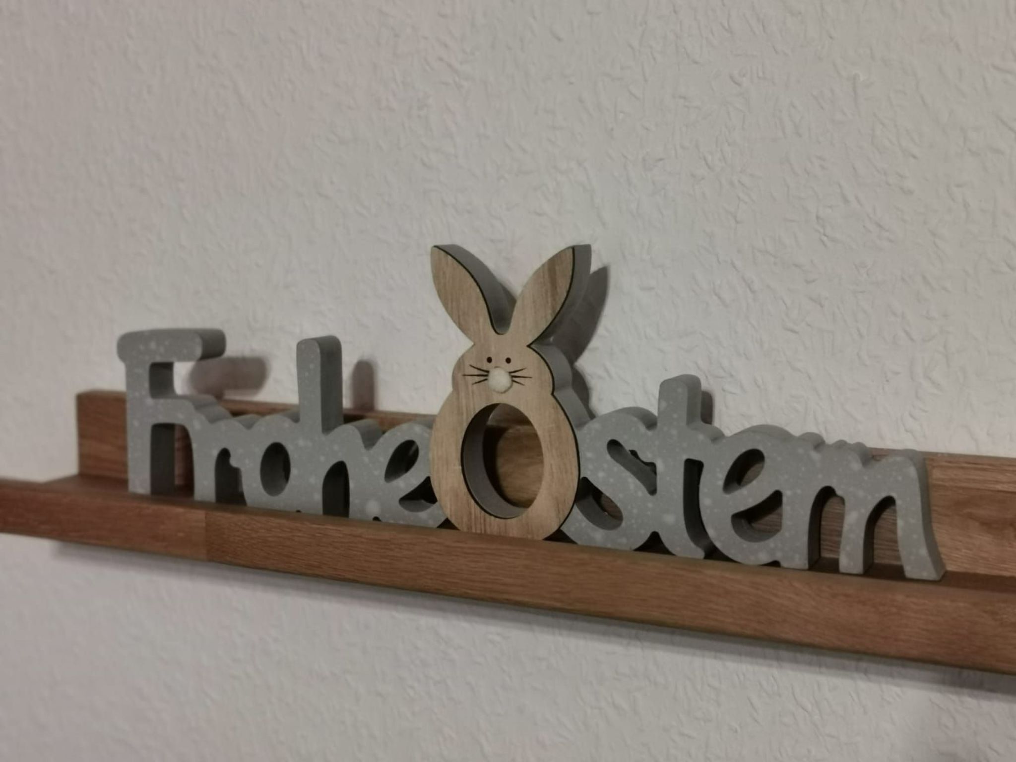A wooden shelf with the name "Freunde" and a rabbit decoration.