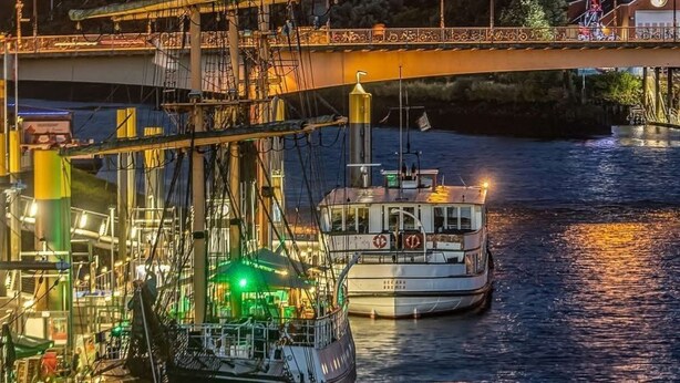 A large sailing ship docked at a harbor with a bridge and a full moon in the background. - Landhaus Markus by Interhome (Süderschwei)
