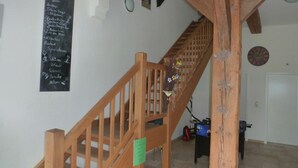 A wooden staircase with a green sign, a chalkboard with text, and a clock on the wall. - Landhaus Markus by Interhome (Süderschwei)