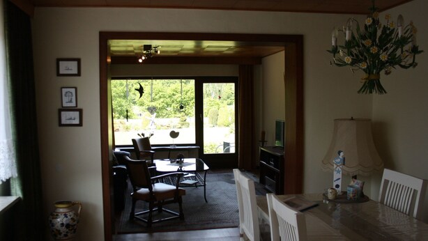 A dining area with a table, chairs, a television, and a vase with flowers. - Ferienhaus by Interhome (Witzeeze)