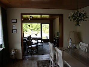 A dining area with a table, chairs, a television, and a vase with flowers. - Ferienhaus by Interhome (Witzeeze)