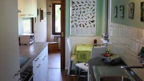 A kitchen with a dining area, wooden flooring, and a wall-mounted poster. - Ferienhaus by Interhome (Witzeeze)
